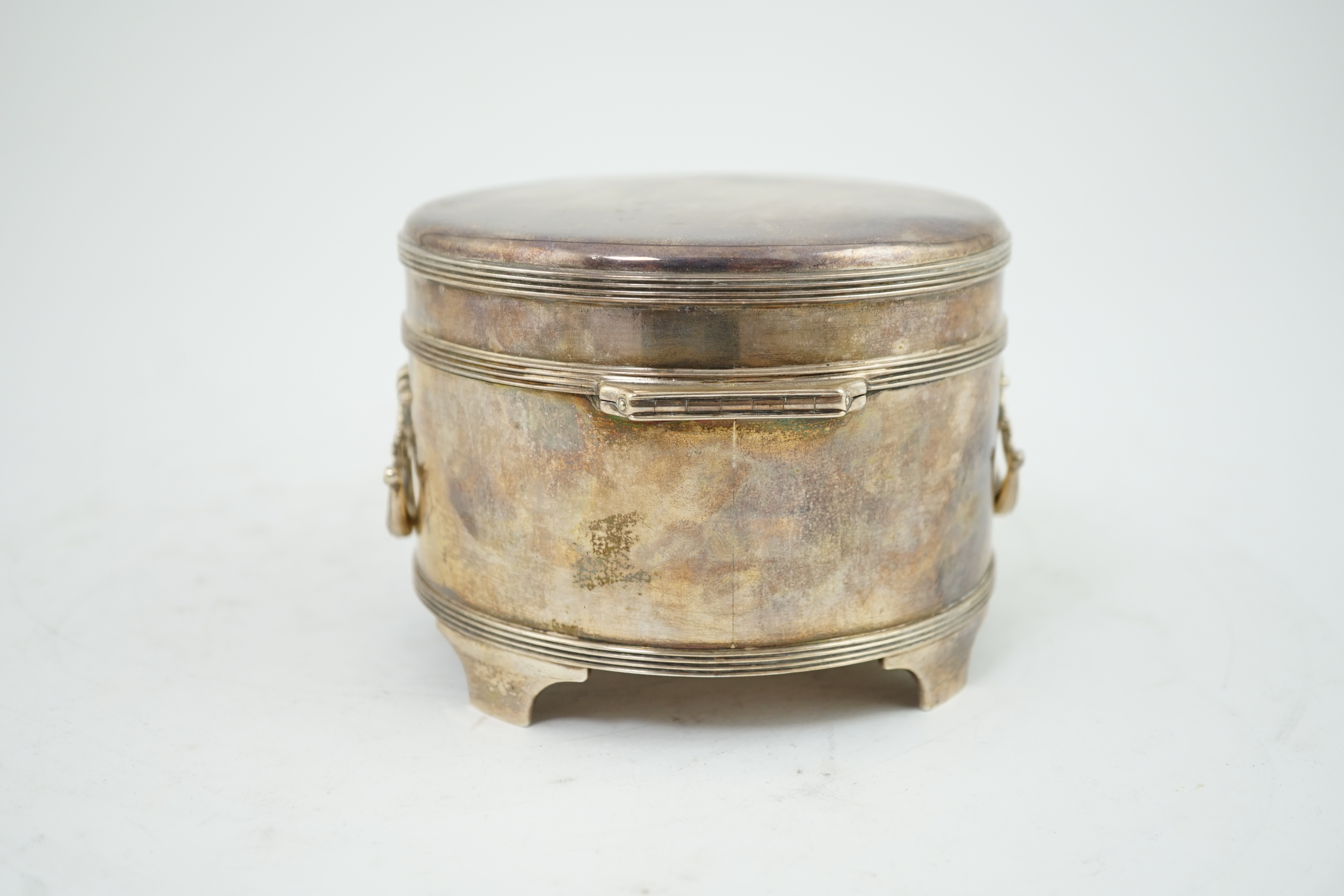 A George V silver circular two handed biscuit box, with hinged cover, by Asprey & Co Ltd